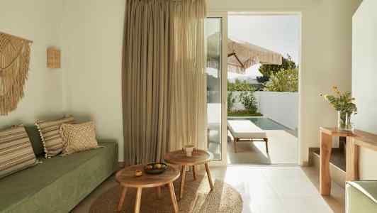 Moderni huone vihreällä sohvalla, puiset huonekalut ja lasiovi, joka johtaa terassille, jossa uima-allas. (Tekoälyn luoma teksti)