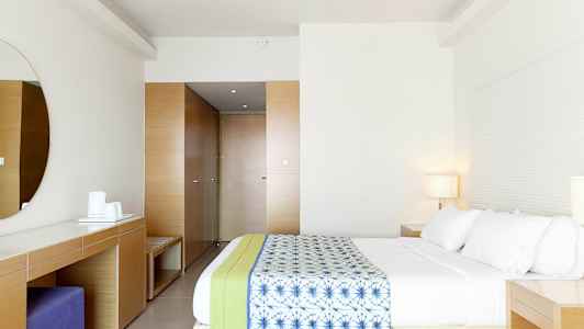 Moderni hotellihuone, jossa tilava sänky ja minimalistinen sisustus. (Tekoälyn luoma teksti)