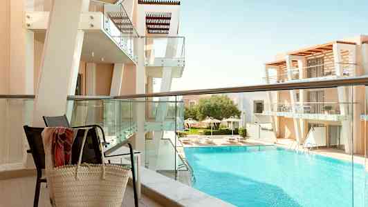 Näkymä parvekkeelta kohti modernia rakennusta ja allasaluetta. (Tekoälyn luoma teksti)