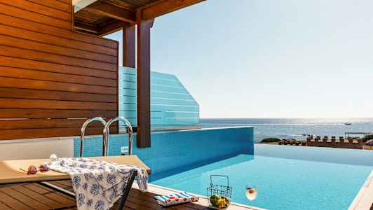 Infinity-allas, josta on näkymä merelle, aurinkotuoli ja juoma. (Tekoälyn luoma teksti)