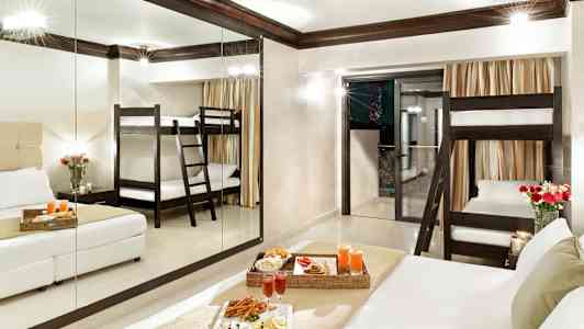 Hotellihuone, jossa on kerrossänky, parisänky ja tarjoiltu ateria. (Tekoälyn luoma teksti)