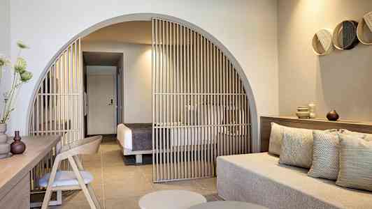 Moderni hotellihuone, jossa istuma-alue ja seinäke makuutilaan. (Tekoälyn luoma teksti)