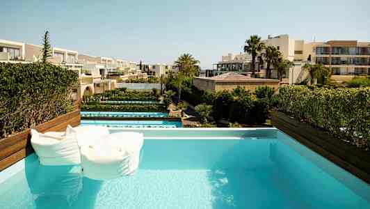 Uima-allas, näkymä hotellirakennuksiin ja puutarhoihin. (Tekoälyn luoma teksti)