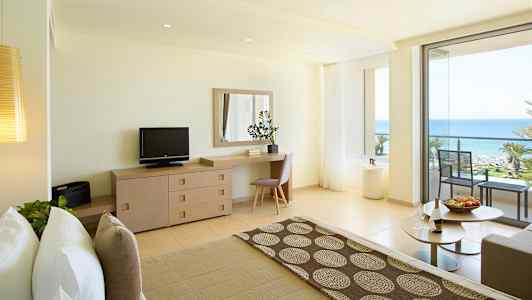 Valoisa hotellihuone, josta on merinäköala ja parveke. (Tekoälyn luoma teksti)