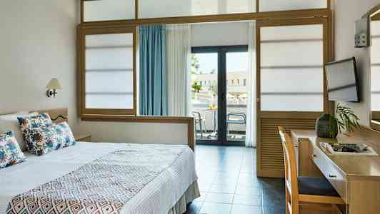 Hotellihuone, jossa sänky, kirjoituspöytä ja parveke. (Tekoälyn luoma teksti)