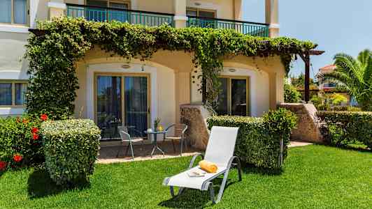 Kuva aurinkotuolista, jossa on pyyhe ja lehti nurmikolla terassin edessä. (Tekoälyn luoma teksti)