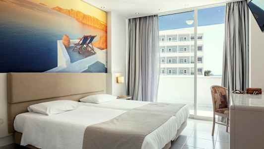 Hotellihuone, jossa on parivuode, suuri seinäkuva rannikkomaisemasta ja parveke näköalalla. (Tekoälyn luoma teksti)