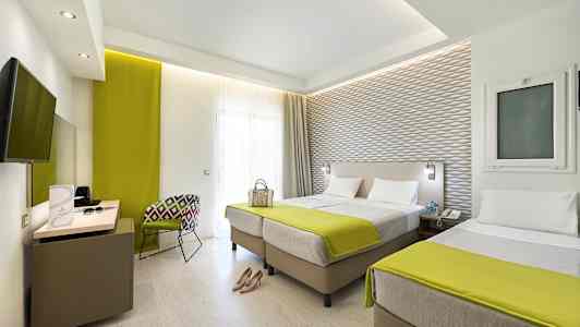 Hotellihuone, jossa kaksi erillistä vuodetta ja nykyaikainen sisustus. (Tekoälyn luoma teksti)