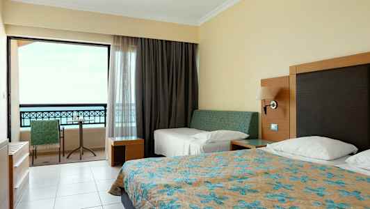 Hotellihuone, jossa sängyt ja parveke. (Tekoälyn luoma teksti)