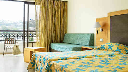 Hotellihuone, jossa on sänky, sohva ja parveke. (Tekoälyn luoma teksti)