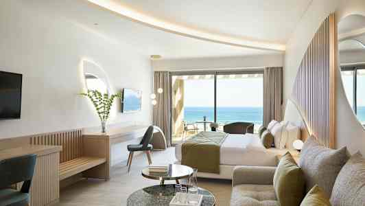 Hotellihuone, jossa on moderni sisustus ja näkymä merelle. (Tekoälyn luoma teksti)