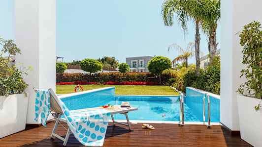 Ulkouima-allas, jota ympäröi vihreys ja aurinkotuolit. (Tekoälyn luoma teksti)