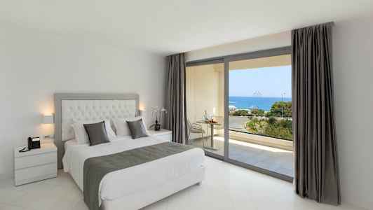 Makuuhuone, jossa on parivuode ja näkymä merelle suurten ikkunoiden kautta. (Tekoälyn luoma teksti)