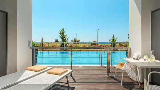 Näkymä terassilta uima-altaalle, taustalla ranta ja meri. (Tekoälyn luoma teksti)