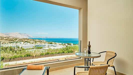 Terassi, jolta näköala merelle ja maisemiin, pöytä, kaksi tuolia ja aurinkotuoli. (Tekoälyn luoma teksti)