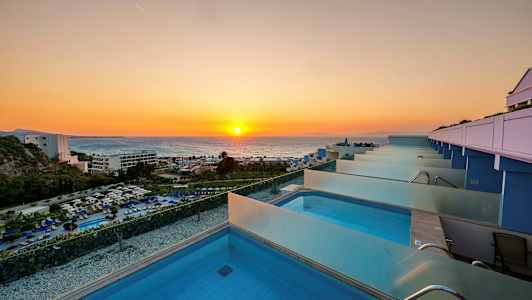 Näkymä yksityisiin uima-altaisiin, taustalla auringonlasku meren yllä. (Tekoälyn luoma teksti)