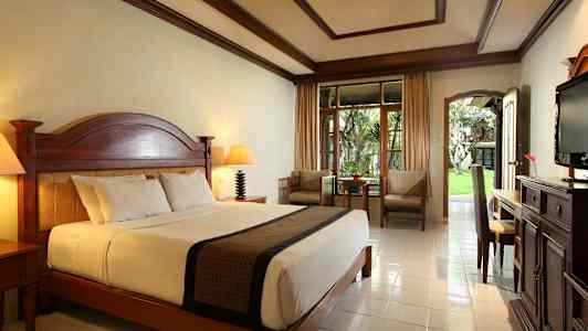 Hyvin sisustettu hotellihuone, jossa on suuri sänky ja ulkoterassi. (Tekoälyn luoma teksti)