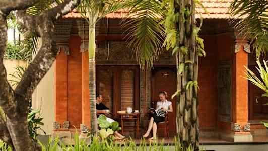 Kaksi henkilöä istuu verannalla talossa, joka on sisustettu perinteiseen tyyliin. (Tekoälyn luoma teksti)