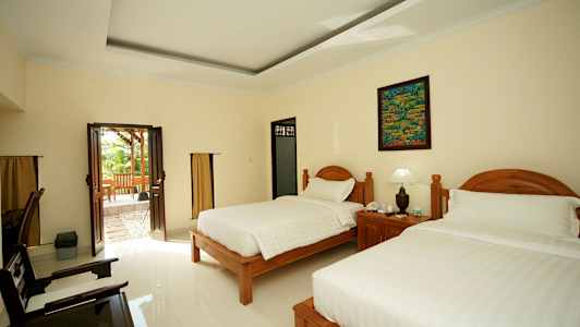 Hotellihuone, jossa kaksi sänkyä ja lasiovi, joka vie ulkoterassille. (Tekoälyn luoma teksti)