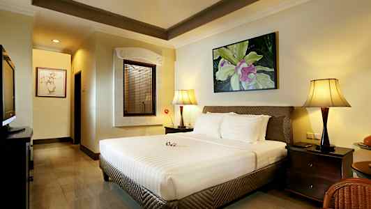 Makuuhuone, jossa on suuri sänky, kaksi yöpöydän lamppua ja koristeellinen taulu seinällä. (Tekoälyn luoma teksti)