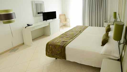 Huone parivuoteella, kirjoituspöytä peilillä ja televisiolla sekä pöytälamppu. (Tekoälyn luoma teksti)