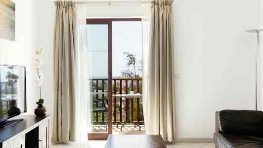 Huone, jossa on istuinryhmä, televisio ja parveke näkymällä. (Tekoälyn luoma teksti)