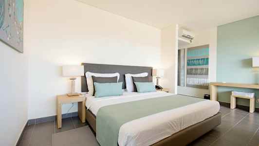 Hotellihuone, jossa suuri sänky, kaksi yöpöytää ja moderni sisustus. (Tekoälyn luoma teksti)