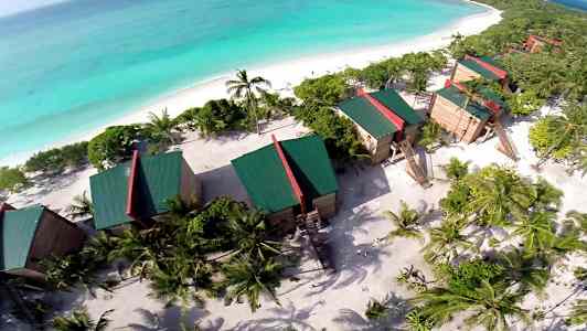 Ilmakuva lomakeskuksesta rannalla ja taustalla meri. (Tekoälyn luoma teksti)