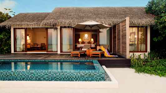 Rantarakennus, jossa on oma uima-allas ja istuimet puuterassilla. (Tekoälyn luoma teksti)