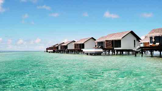 Mökit paalujen päällä turkoosin veden yllä. (Tekoälyn luoma teksti)