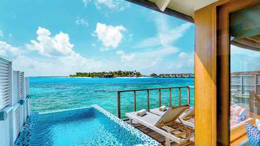 Näkymä terassilta, jossa uima-allas ja aurinkotuoleja, merelle ja saarelle, jolla on bungaloweja. (Tekoälyn luoma teksti)