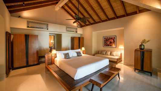 Makuuhuone, jossa suuri sänky, puukalusteet ja korkea katto. (Tekoälyn luoma teksti)