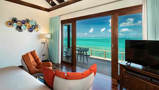 Hotellihuoneen sisustus huonekaluilla, koriste-elementeillä ja näkymällä merelle. (Tekoälyn luoma teksti)