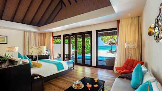 Tilava huone, jossa on sänky, istumapaikkoja ja näkymä altaalle ja merelle suurten ikkunoiden kautta. (Tekoälyn luoma teksti)