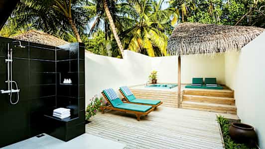 Ulkosuihku aurinkotuolien ja porealtaan vieressä terassilla, jota ympäröivät palmut. (Tekoälyn luoma teksti)
