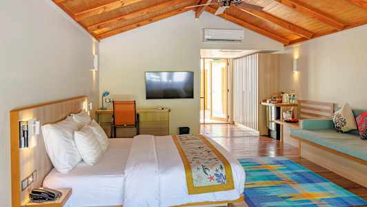 Vaaleasti sisustettu hotellihuone, jossa on parivuode, taulutelevisio ja istuinryhmä. (Tekoälyn luoma teksti)