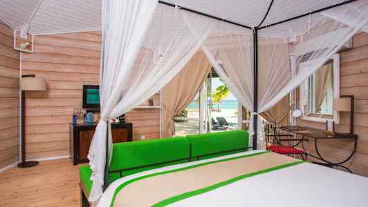 Valoisa makuuhuone katosvuoteella ja näkymä rannalle. (Tekoälyn luoma teksti)