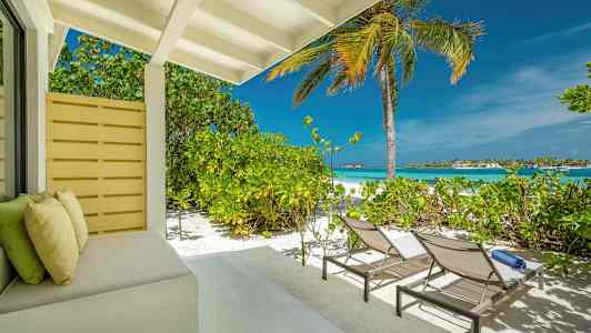 Rantaterassi aurinkotuoleilla, palmulla ja näkymällä merelle. (Tekoälyn luoma teksti)