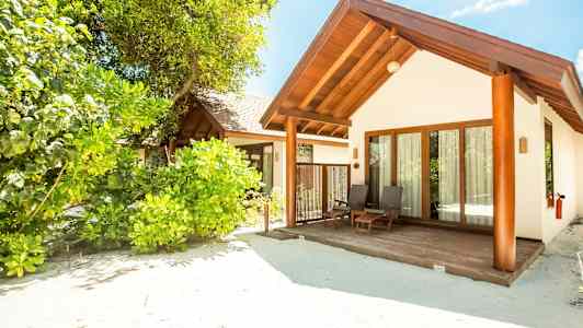 Rantahuvila vehreän kasvillisuuden keskellä. (Tekoälyn luoma teksti)