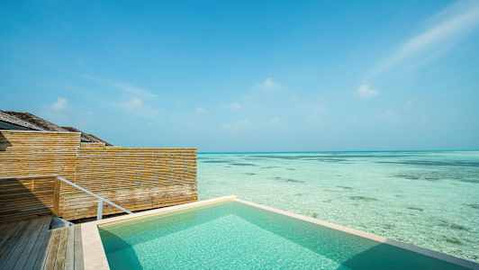 Uima-allas meren rannalla, puuaidat ja kirkas sininen taivas. (Tekoälyn luoma teksti)