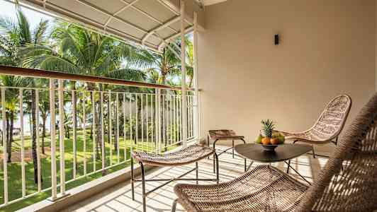 Sisustettu parveke näkymällä puutarhaan, jossa on palmuja. (Tekoälyn luoma teksti)