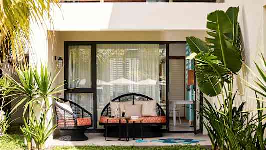 Terassi, jossa tuoleja, pöytä ja kasveja asunnon edessä. (Tekoälyn luoma teksti)