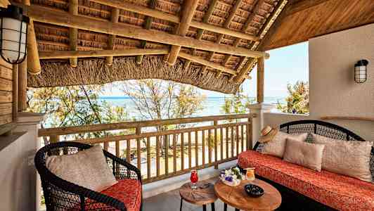 Terassi, jolla on istuimia, pöytä ja näkymä merelle. (Tekoälyn luoma teksti)