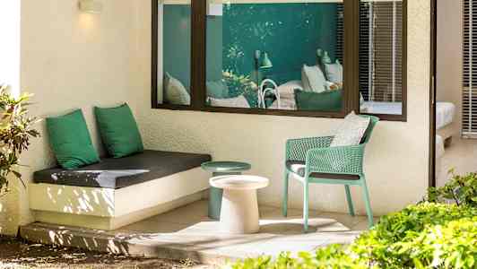 Ulkona istuma-alue vihreällä sisustuksella ja näkymä makuuhuoneeseen. (Tekoälyn luoma teksti)