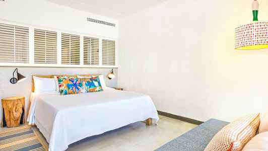 Hotellihuone, jossa on parivuode, koristeellinen tyynykuvio ja nykyaikainen valaistus. (Tekoälyn luoma teksti)