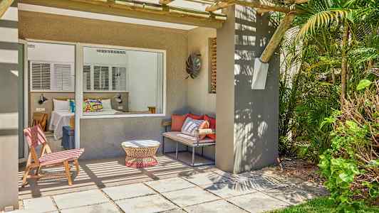 Terassi istumapaikoilla ja näkymä makuuhuoneeseen suuren ikkunan läpi. (Tekoälyn luoma teksti)