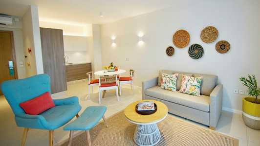 Moderni asunto, jossa on sohva, nojatuoli, ruokapöytä ja keittokomero. (Tekoälyn luoma teksti)