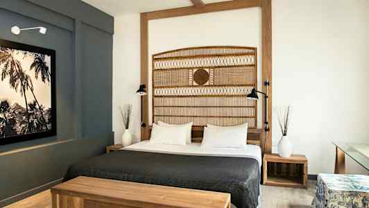 Hotellihuone, jossa on parivuode, puukalusteet ja moderni sisustus. (Tekoälyn luoma teksti)