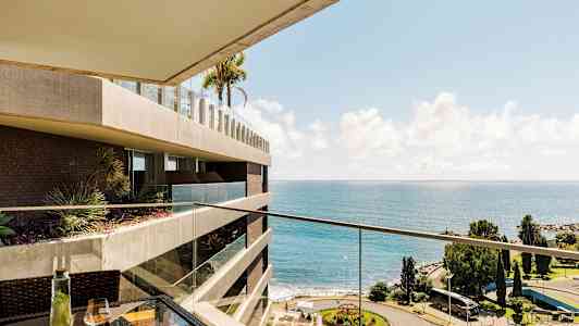 Näkymä parvekkeelta merelle ja puistoon. (Tekoälyn luoma teksti)