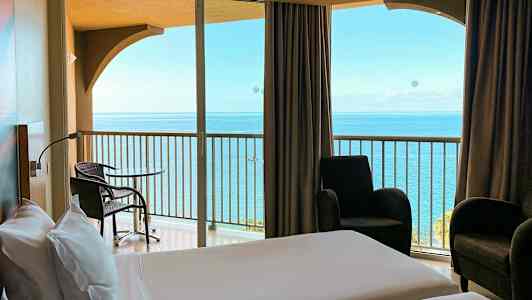 Hotellihuone, josta näkymä merelle parvekkeelta. (Tekoälyn luoma teksti)